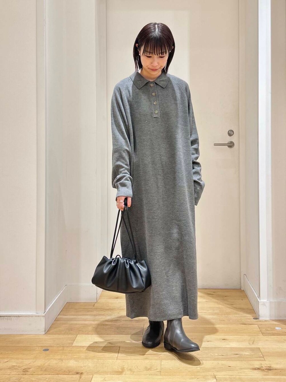 グレー系のブーツ、ホワイト系のブルゾン、グレー系のワンピースを着用したレディースの冬コーディネートの6枚目の写真