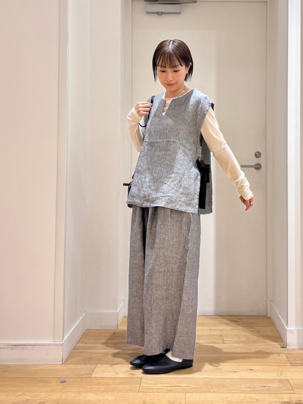 ホワイト系のTシャツ/カットソー、グレー系のベスト、グレー系のその他パンツを着用したレディースの春コーディネートの4枚目の写真