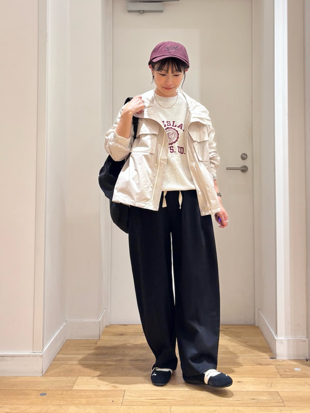ホワイト系のナイロンジャケット、ブラック系のその他パンツ、ブラック系のスニーカーを着用したレディースの春コーディネートの2枚目の写真