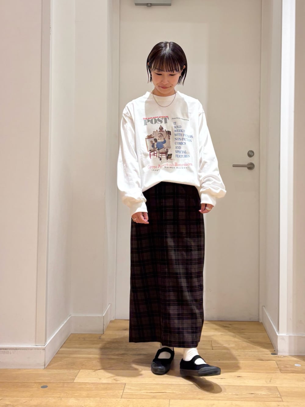 ホワイト系のTシャツ/カットソー、ベージュ系のスカート、ブラック系のショルダーバッグを着用したレディースの冬コーディネートの6枚目の写真