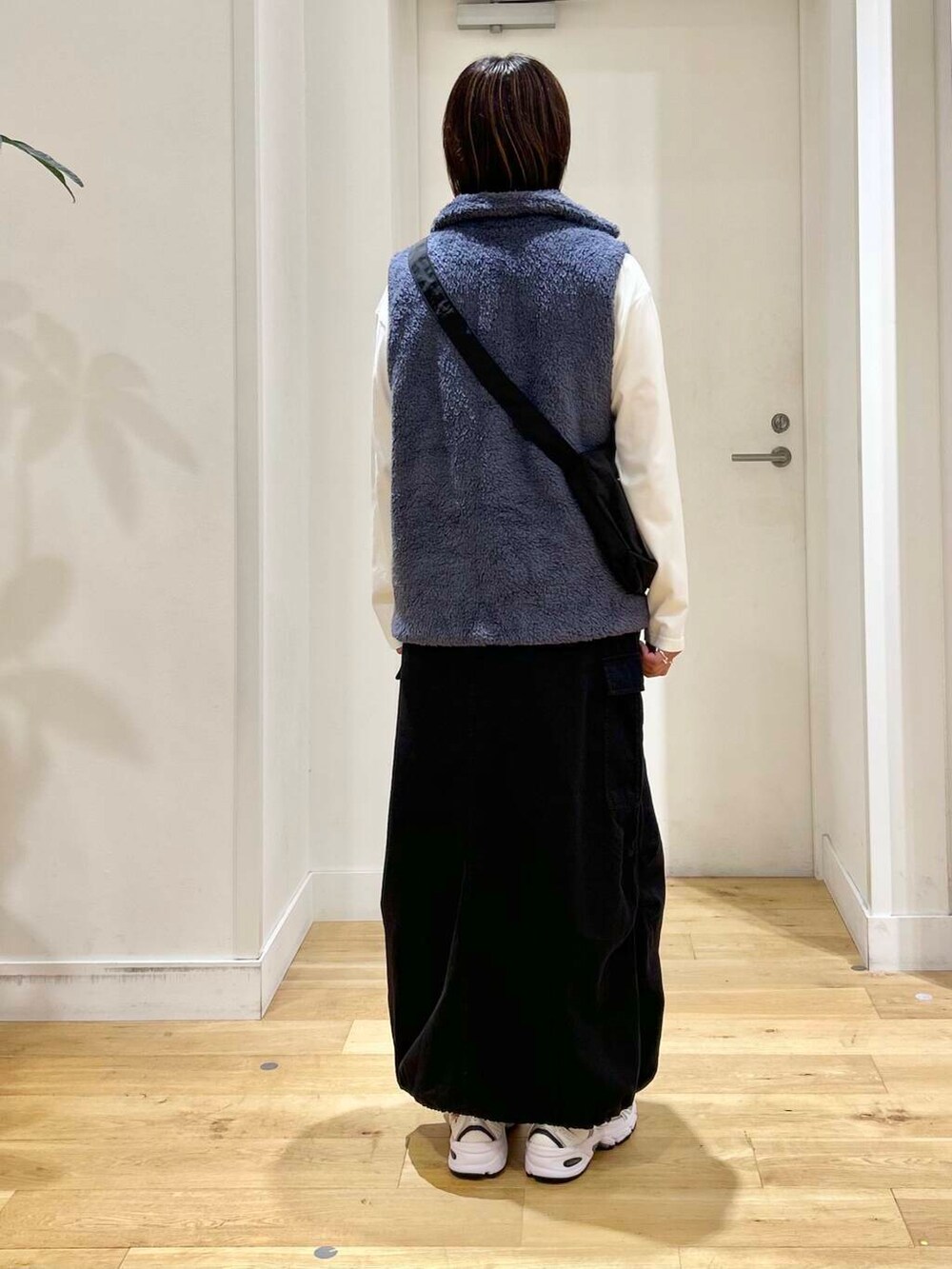 ブラック系のショルダーバッグ、ブラック系のスカート、ホワイト系のTシャツ/カットソーを着用したレディースの秋コーディネートの5枚目の写真
