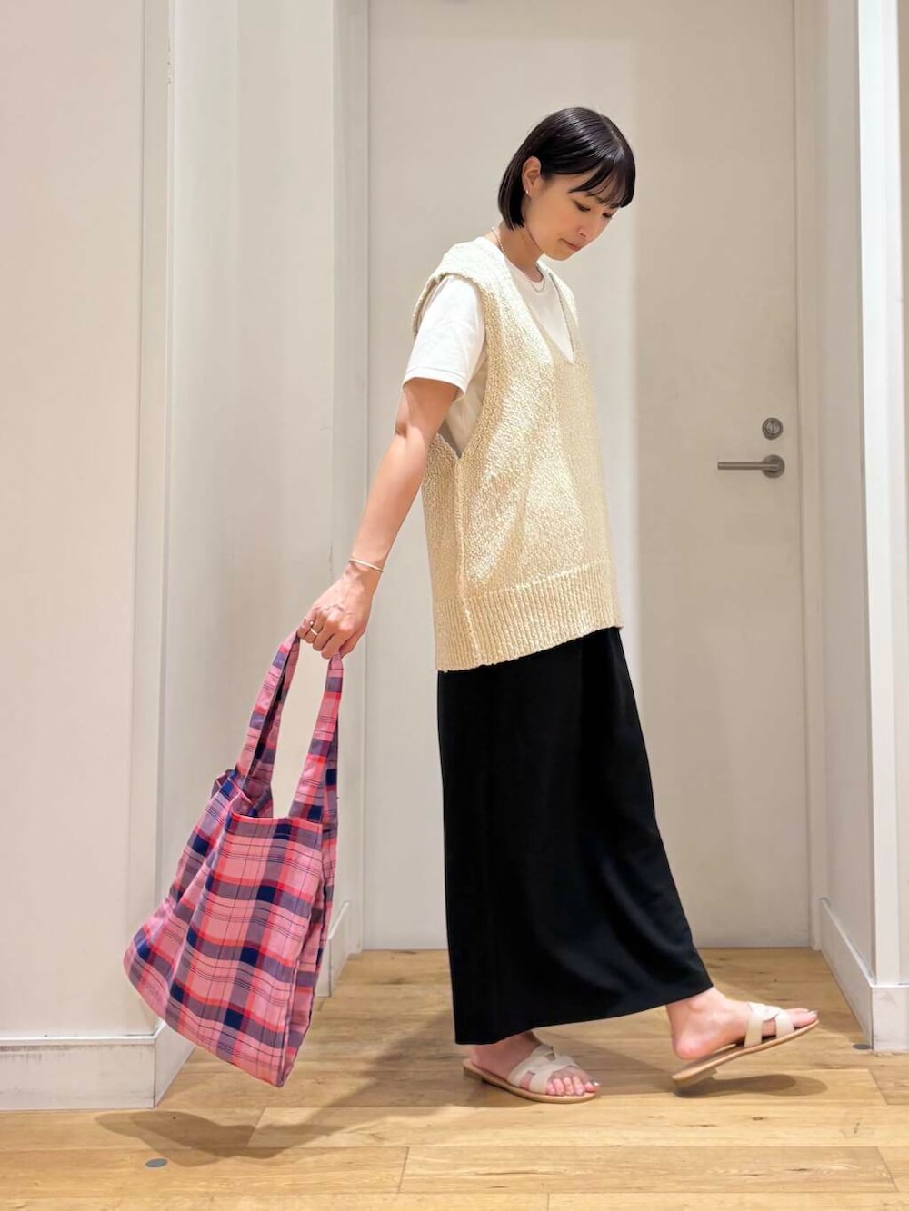 ホワイト系のサンダル、ホワイト系のTシャツ/カットソー、ブラック系のスカートを着用したレディースの夏コーディネートの5枚目の写真