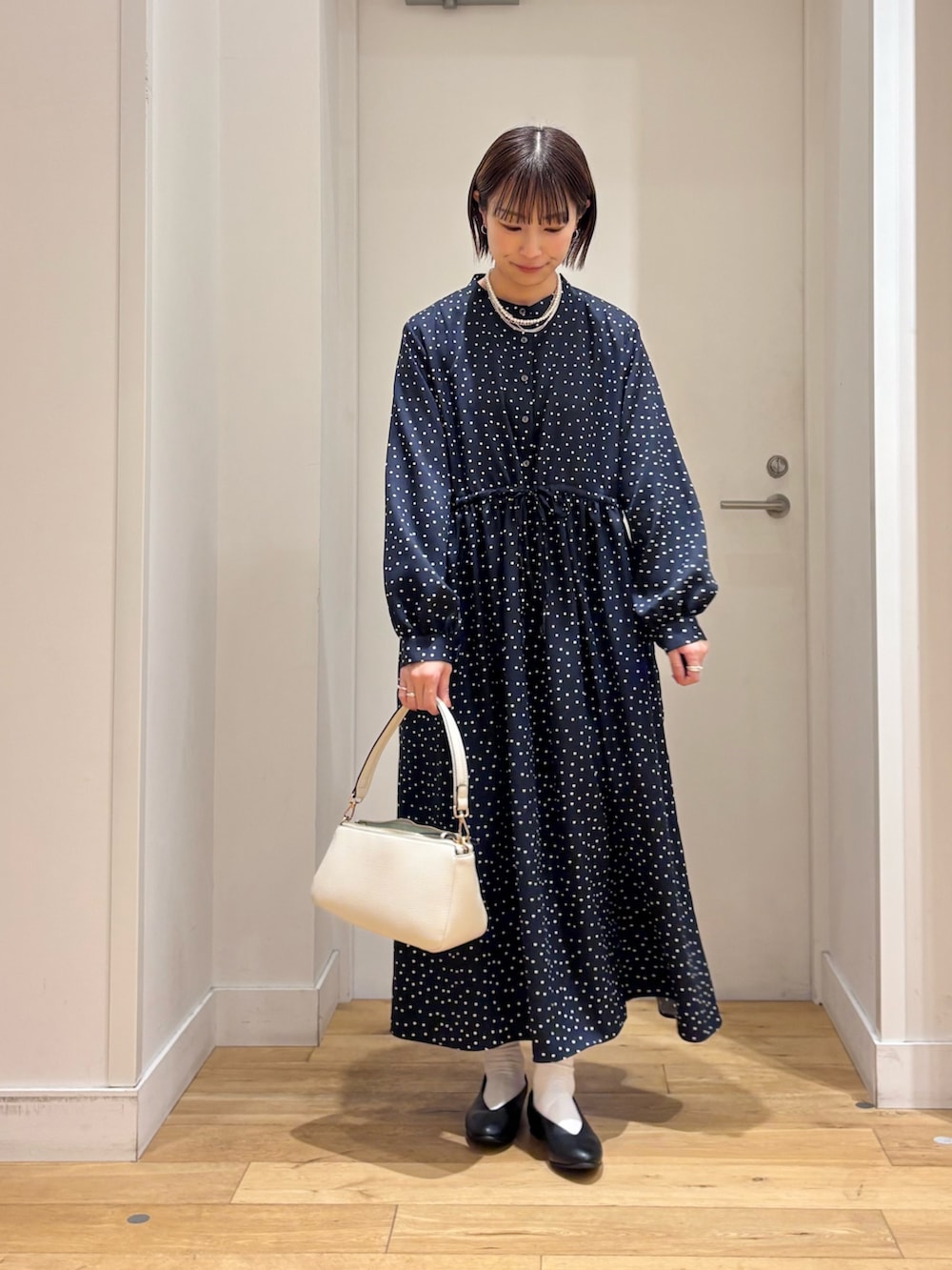 ブルー系のワンピース、グレー系のその他アウター、ホワイト系のショルダーバッグを着用したレディースの冬コーディネートの6枚目の写真