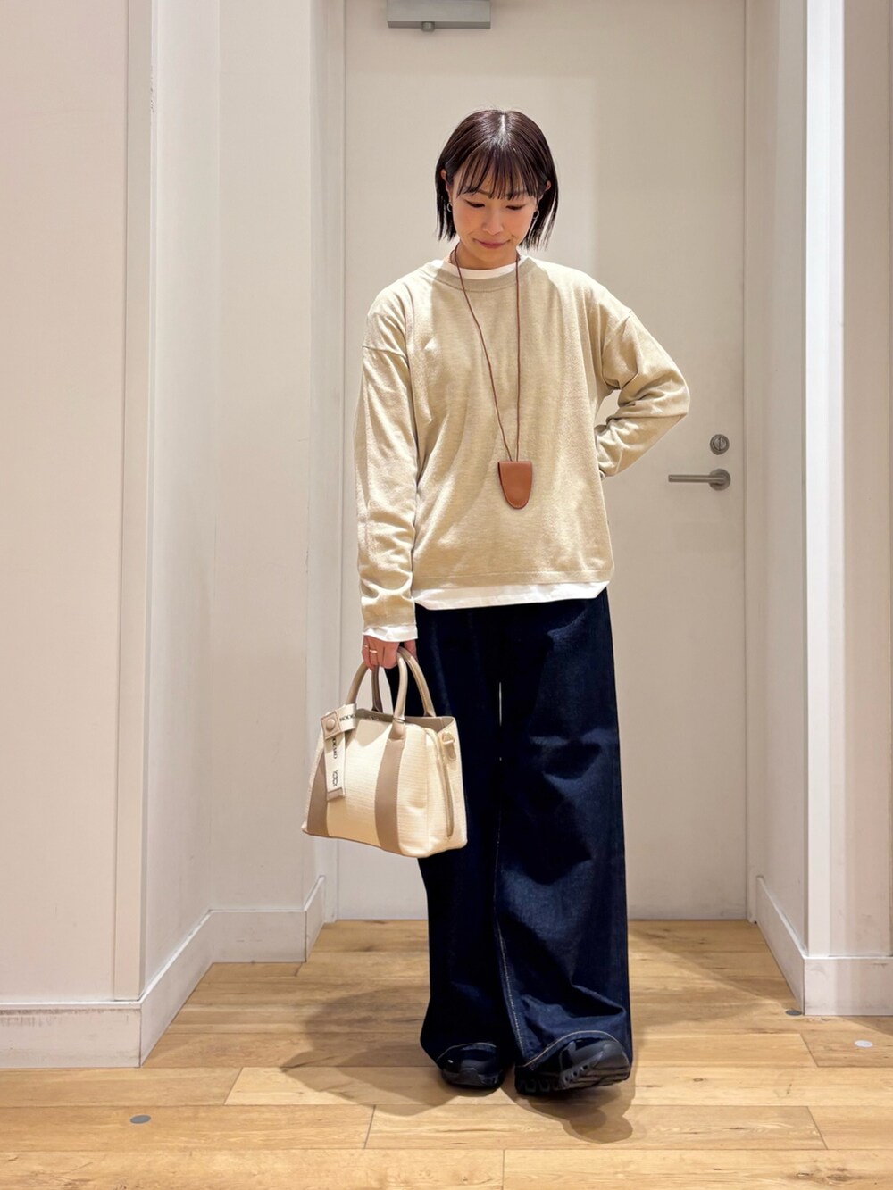 ベージュ系のブルゾン、ベージュ系のニット/セーター、ホワイト系のハンドバッグを着用したレディースの冬コーディネートの7枚目の写真