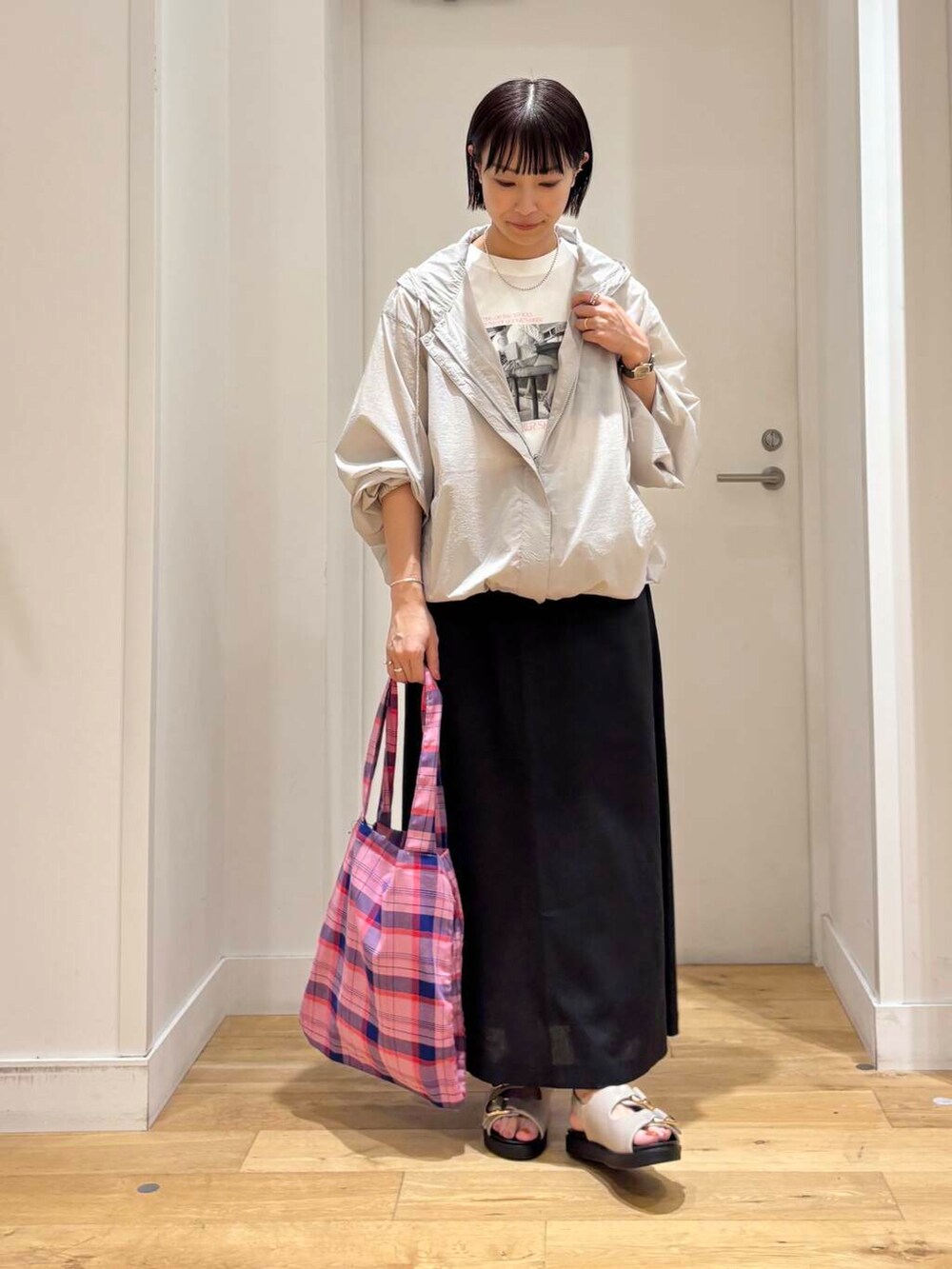 グレー系のマウンテンパーカー、グレー系のサンダル、ホワイト系のTシャツ/カットソーを着用したレディースの夏コーディネートの2枚目の写真