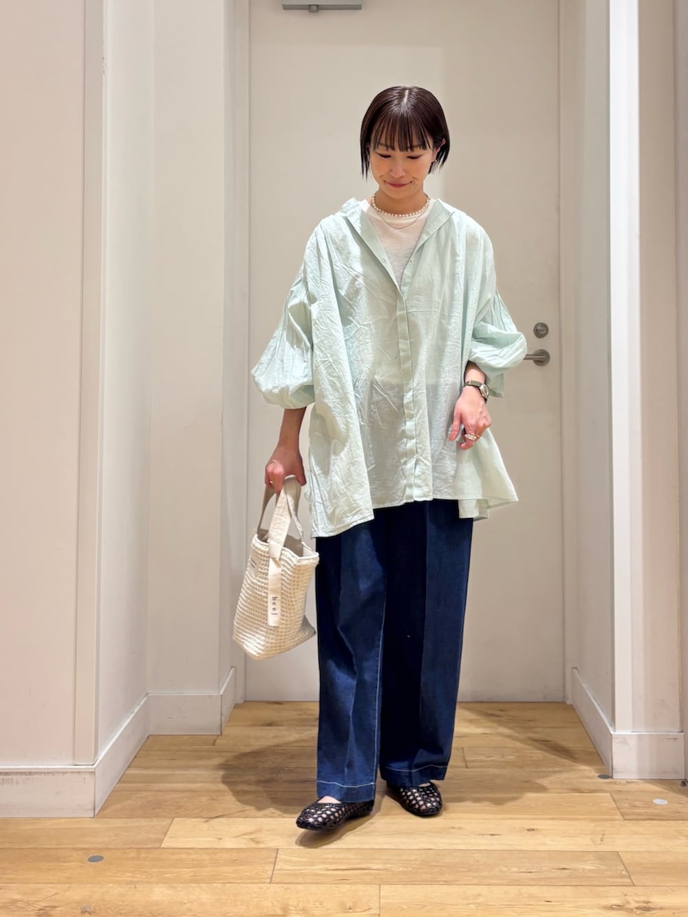 グリーン系のシャツ/ブラウス、ホワイト系のTシャツ/カットソー、ブルー系のデニムパンツを着用したレディースの春コーディネートの4枚目の写真