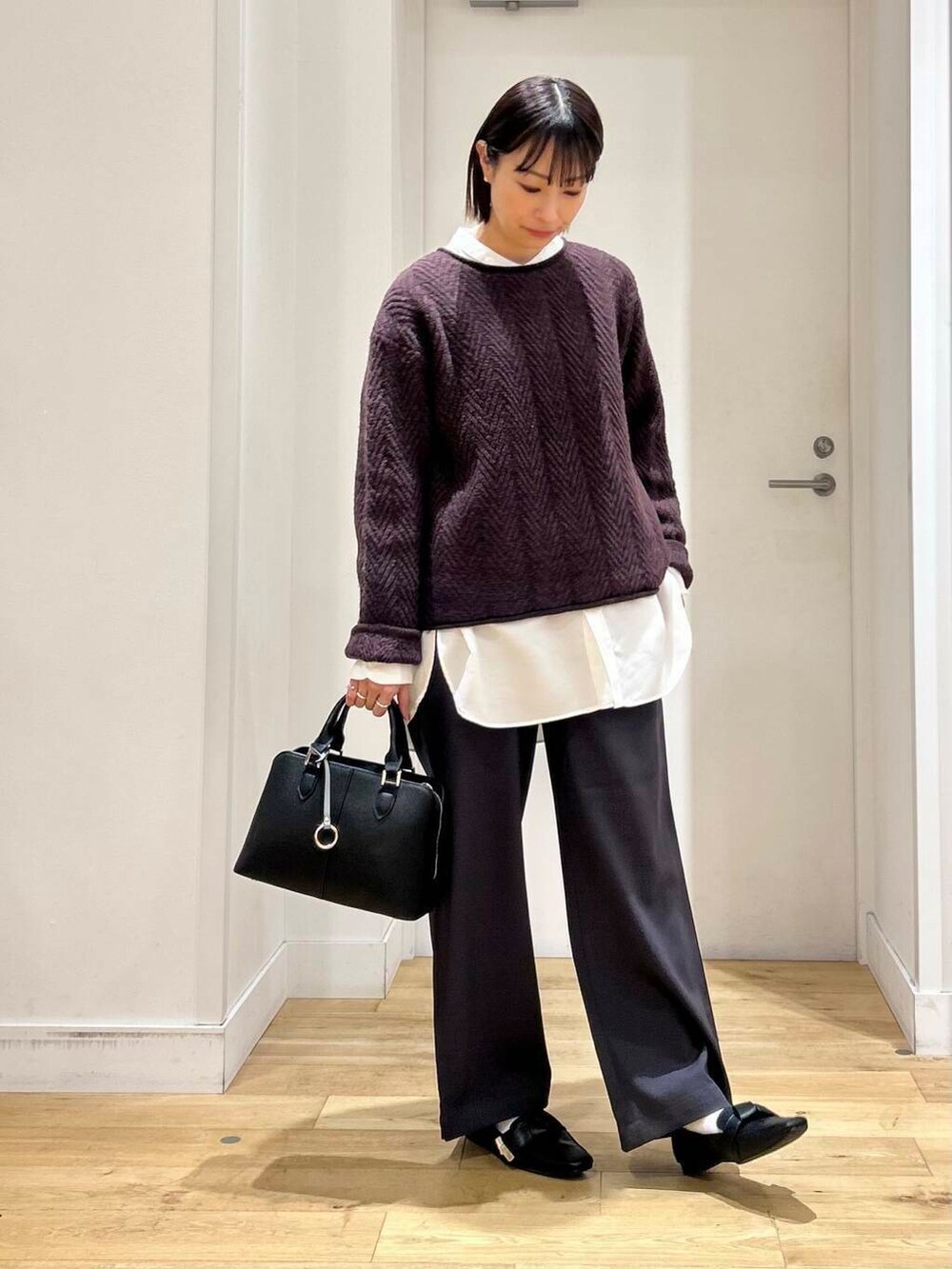 ブラック系のドレスシューズ、ホワイト系のシャツ/ブラウス、ブラック系のハンドバッグを着用したレディースの冬コーディネートの4枚目の写真