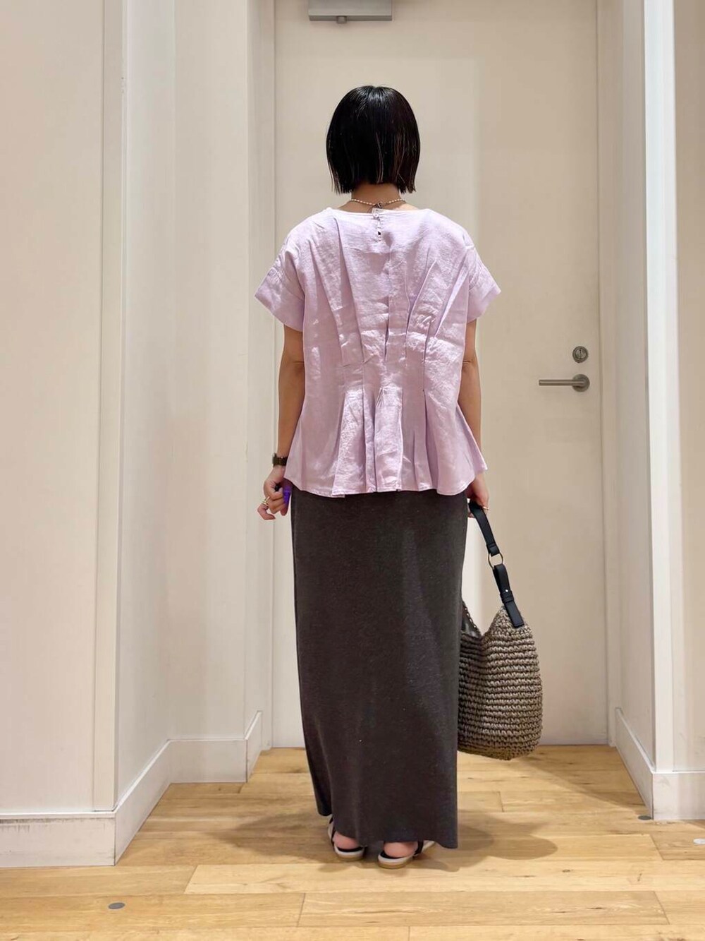 グレー系のトートバッグ、ブラック系のサンダル、グレー系のスカートを着用したレディースの夏コーディネートの5枚目の写真