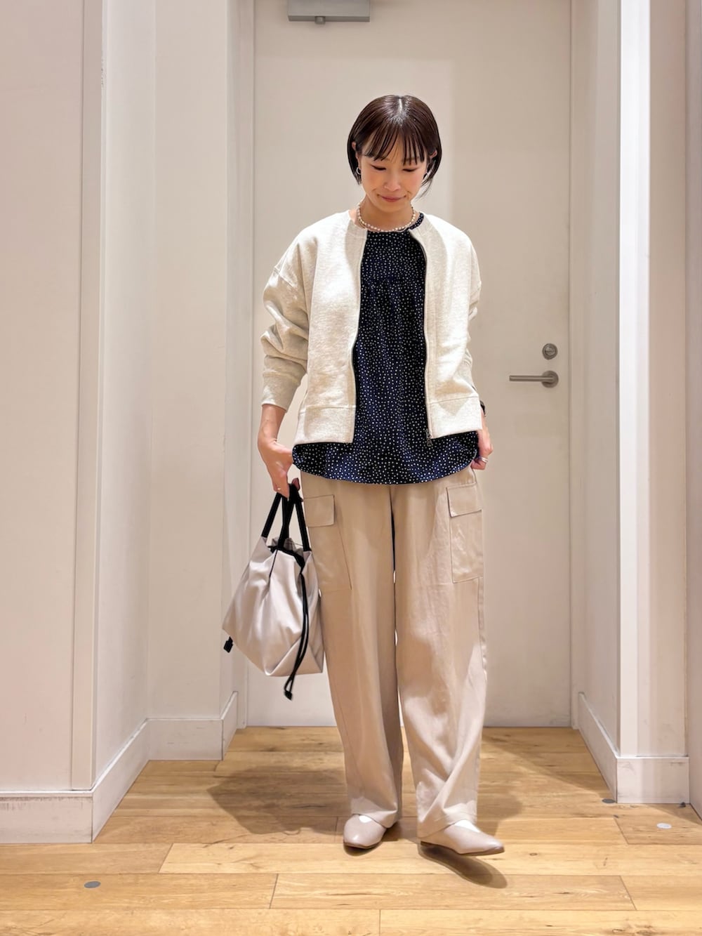 ホワイト系のカーディガン/ボレロ、ブルー系のシャツ/ブラウス、ベージュ系のその他パンツを着用したレディースの春コーディネートの4枚目の写真