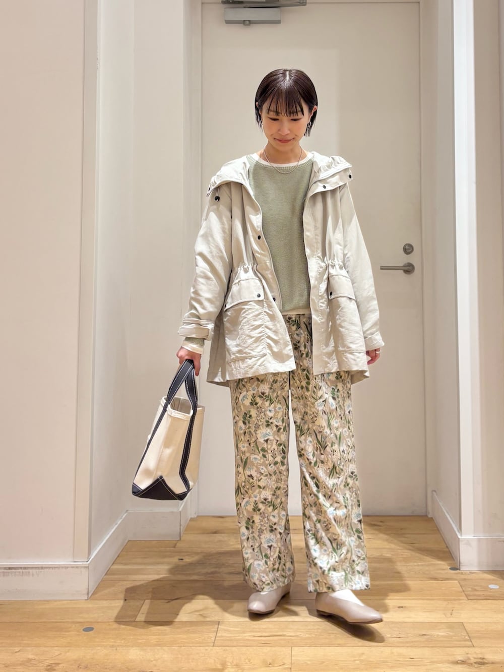 ベージュ系のマウンテンパーカー、グリーン系のニット/セーター、グレー系のパンプスを着用したレディースの春コーディネートの3枚目の写真