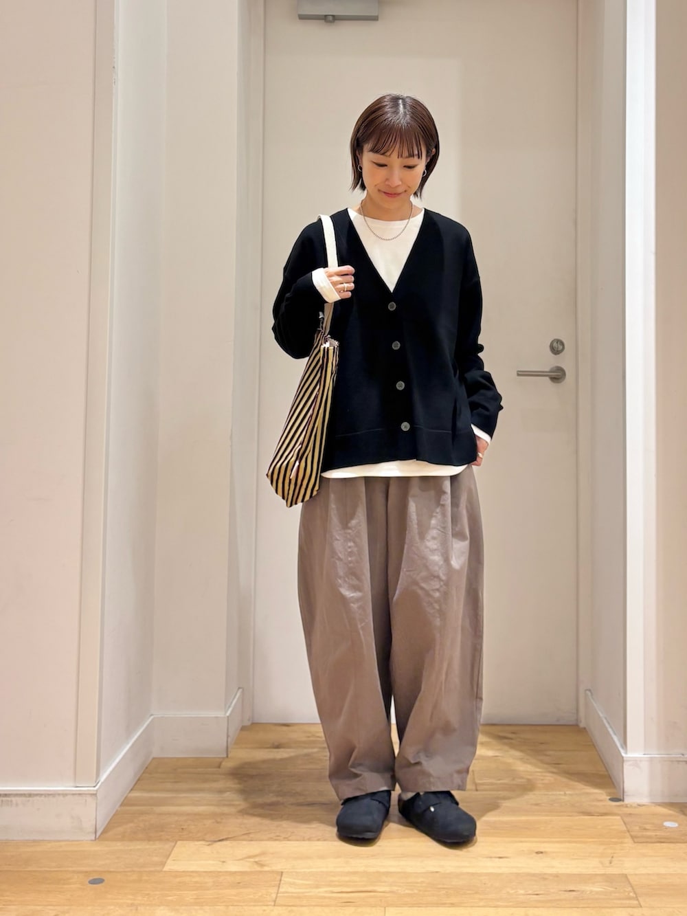 ブラック系のカーディガン/ボレロ、ホワイト系のTシャツ/カットソー、ブラック系のその他シューズを着用したレディースの秋コーディネートの3枚目の写真