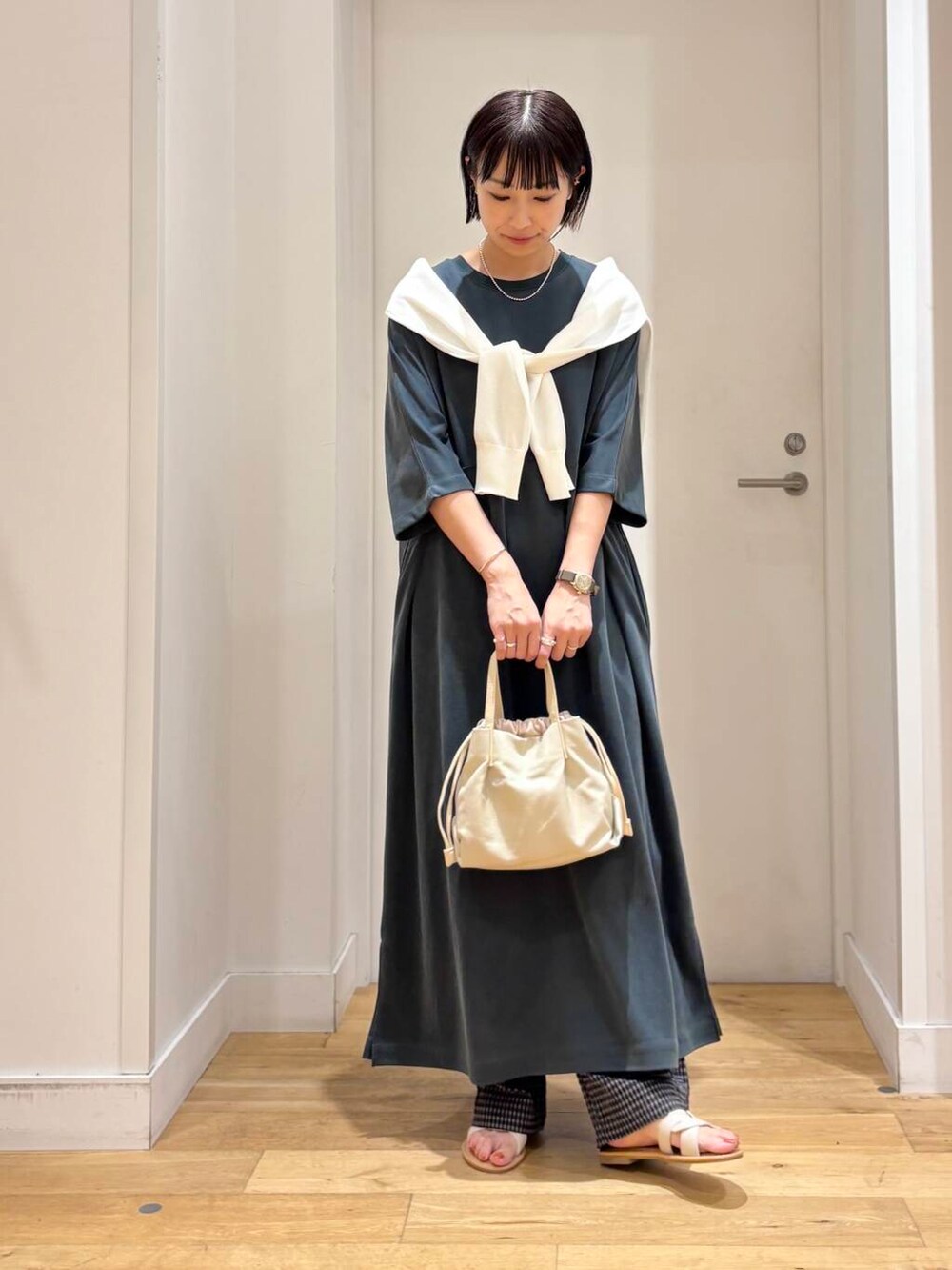 ホワイト系のサンダル、ホワイト系のカーディガン/ボレロ、グレー系のその他パンツを着用したレディースの夏コーディネートの2枚目の写真