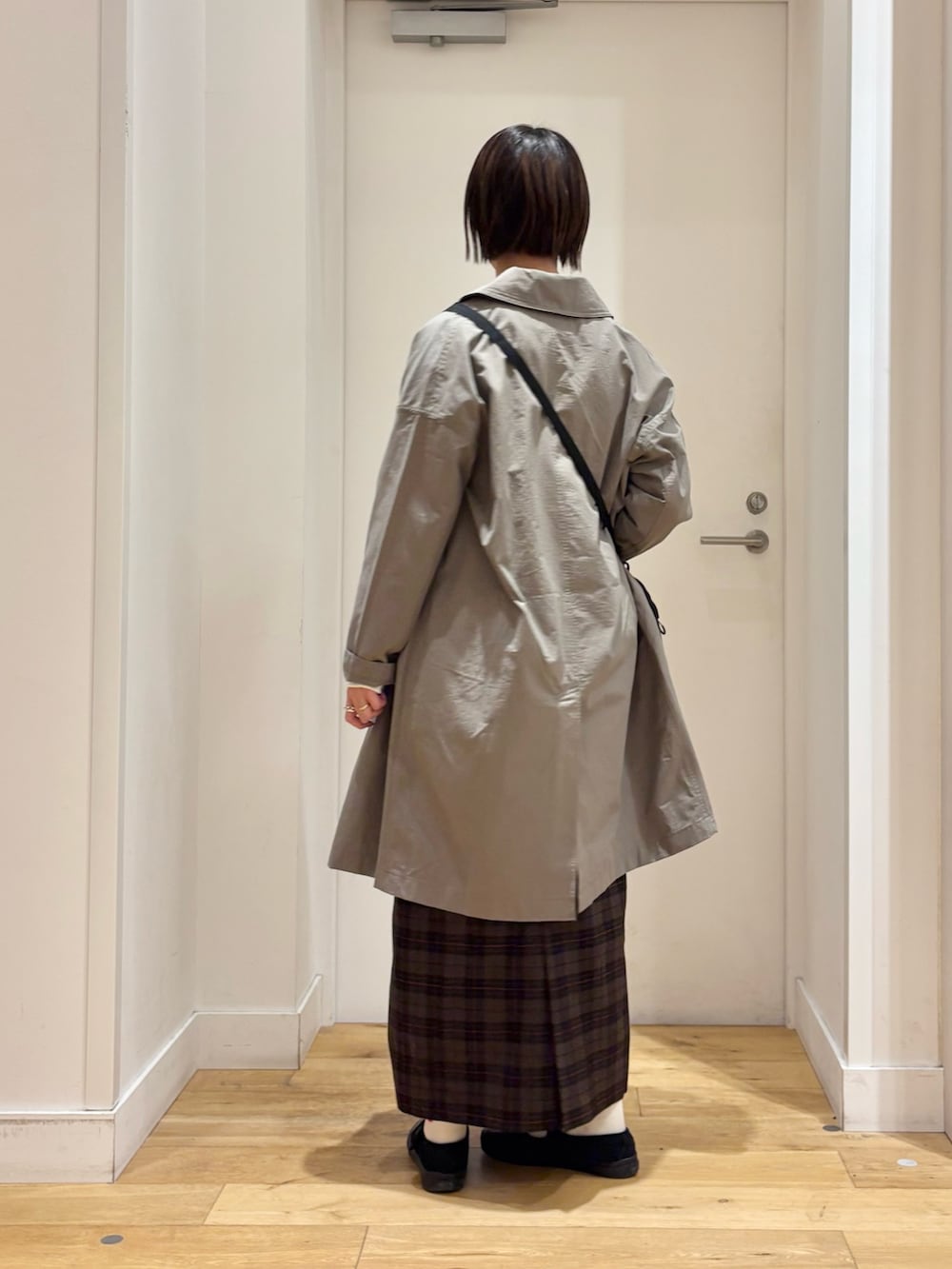 ホワイト系のTシャツ/カットソー、ベージュ系のスカート、ブラック系のショルダーバッグを着用したレディースの冬コーディネートの5枚目の写真