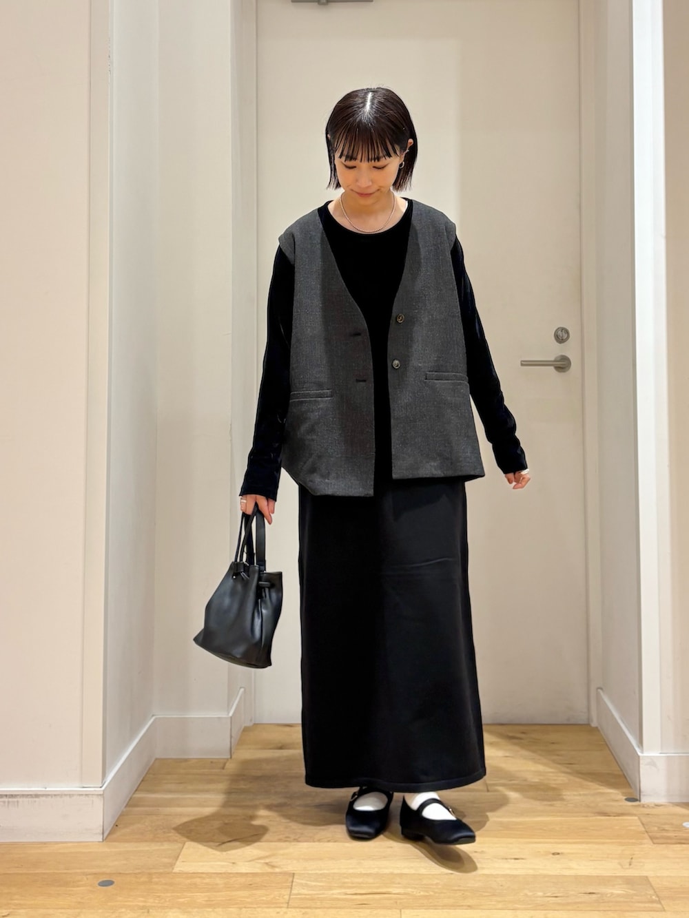 ブラック系のショルダーバッグ、ブラック系のTシャツ/カットソー、ブラック系のその他アウターを着用したレディースの秋コーディネートの3枚目の写真