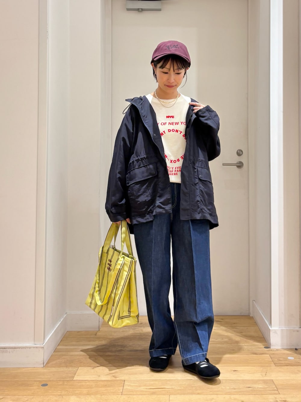 ブルー系のマウンテンパーカー、ホワイト系のTシャツ/カットソー、イエロー系のトートバッグを着用したレディースの春コーディネートの3枚目の写真