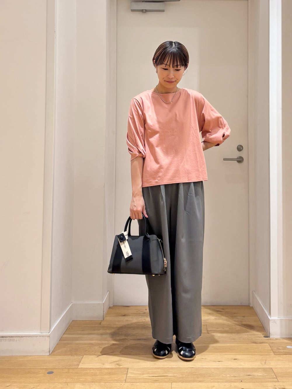 ピンク系のTシャツ/カットソー、グレー系のその他パンツ、ブラック系のサンダルを着用したレディースの春コーディネートの2枚目の写真