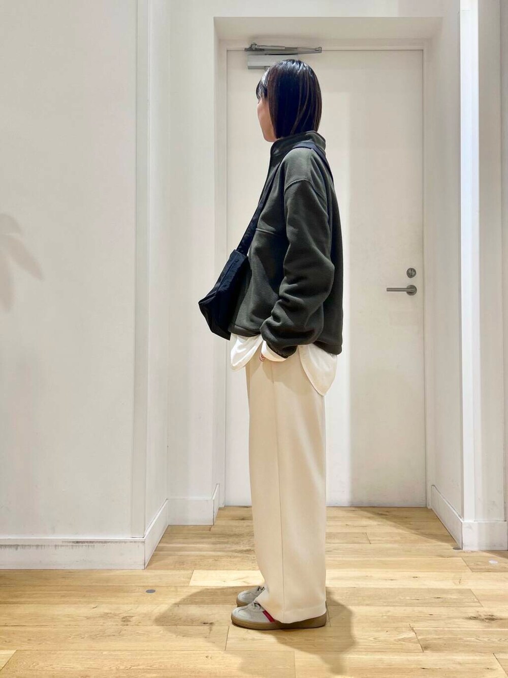 ブラック系のショルダーバッグ、ホワイト系のその他パンツ、ホワイト系のTシャツ/カットソーを着用したレディースの冬コーディネートの2枚目の写真