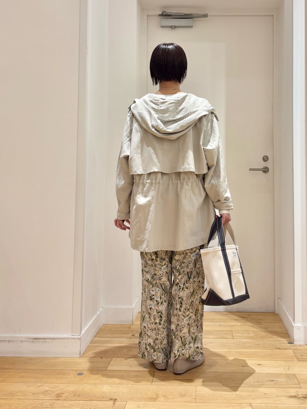 ベージュ系のマウンテンパーカー、グリーン系のニット/セーター、グレー系のパンプスを着用したレディースの春コーディネートの6枚目の写真