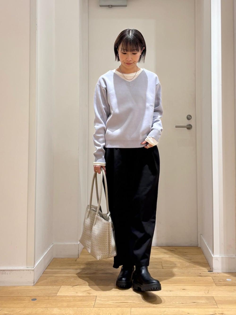 ブラック系のその他パンツ、ホワイト系のトートバッグ、ブラック系のブーツを着用したレディースの冬コーディネートの2枚目の写真