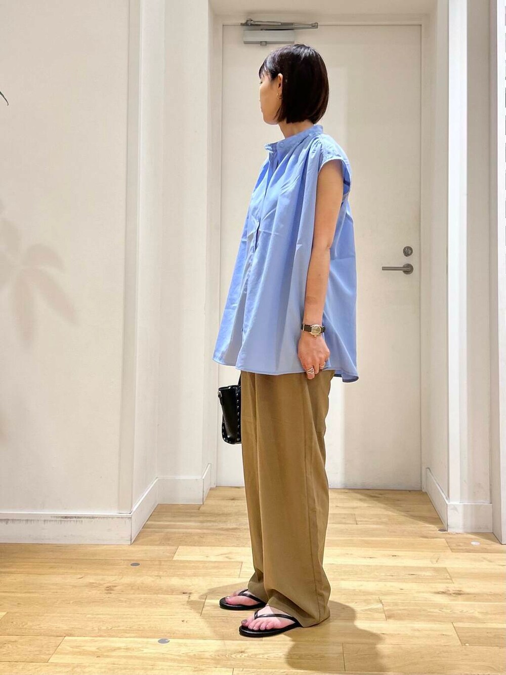 ブラック系のサンダル、ブラック系のショルダーバッグ、ブルー系のシャツ/ブラウスを着用したレディースの夏コーディネートの4枚目の写真