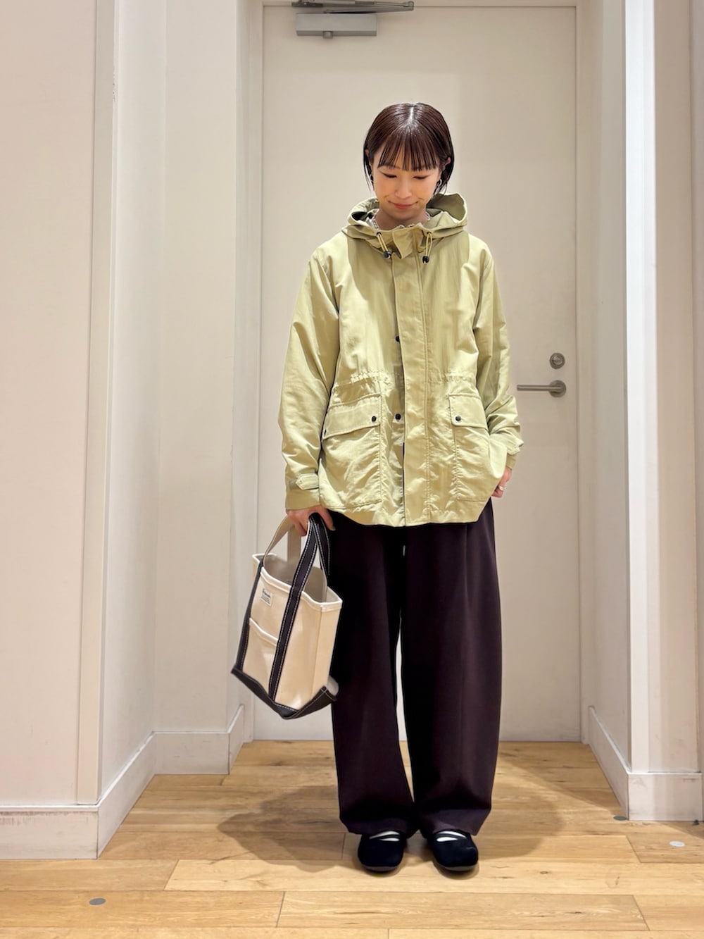 グリーン系のマウンテンパーカー、ホワイト系のTシャツ/カットソー、ブラック系のスニーカーを着用したレディースの春コーディネートの6枚目の写真