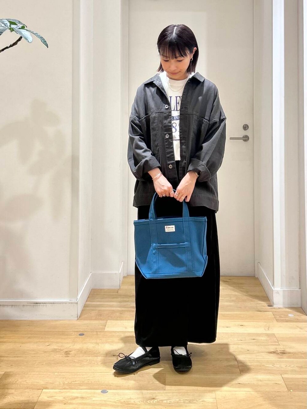 ホワイト系のTシャツ/カットソー、ブラック系のバレエシューズ、グレー系のブルゾンを着用したレディースの秋コーディネートの2枚目の写真