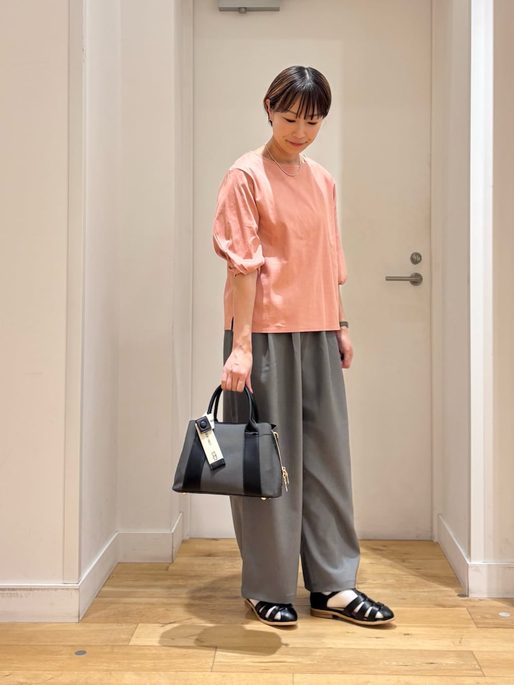 ピンク系のTシャツ/カットソー、グレー系のその他パンツ、ブラック系のサンダルを着用したレディースの春コーディネートの4枚目の写真