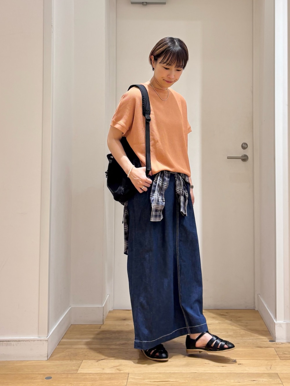 レッド系のTシャツ/カットソー、ブルー系のシャツ/ブラウス、ブルー系のスカートを着用したレディースの春コーディネートの4枚目の写真