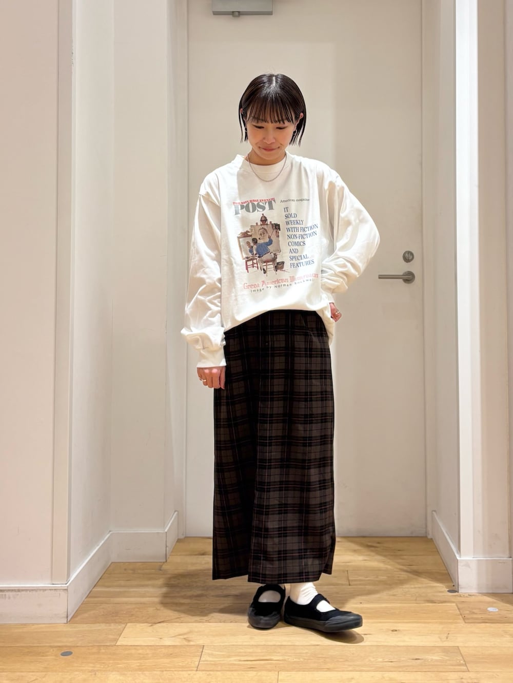 ホワイト系のTシャツ/カットソー、ベージュ系のスカート、ブラック系のショルダーバッグを着用したレディースの冬コーディネートの7枚目の写真