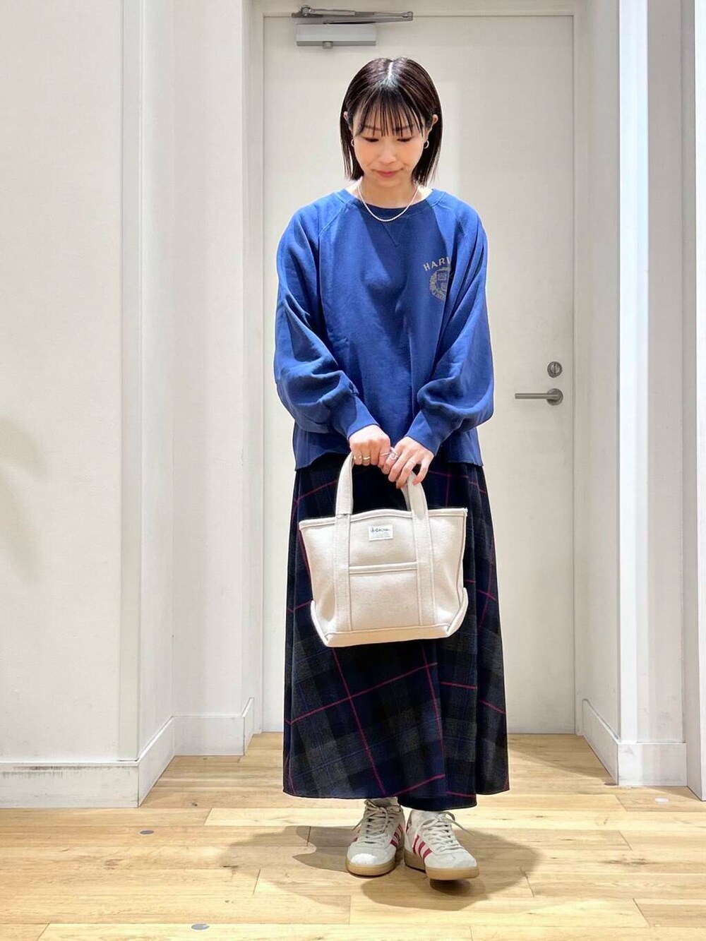 ブルー系のTシャツ/カットソー、ベージュ系のトートバッグ、ホワイト系のスニーカーを着用したレディースの秋コーディネートの2枚目の写真