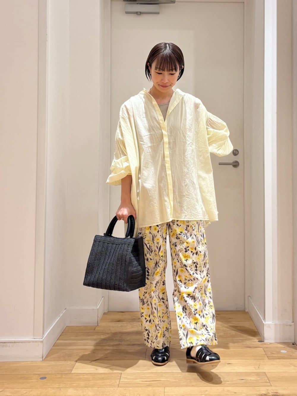 ベージュ系のタンクトップ、イエロー系のシャツ/ブラウス、ブラック系のサンダルを着用したレディースの春コーディネートの4枚目の写真