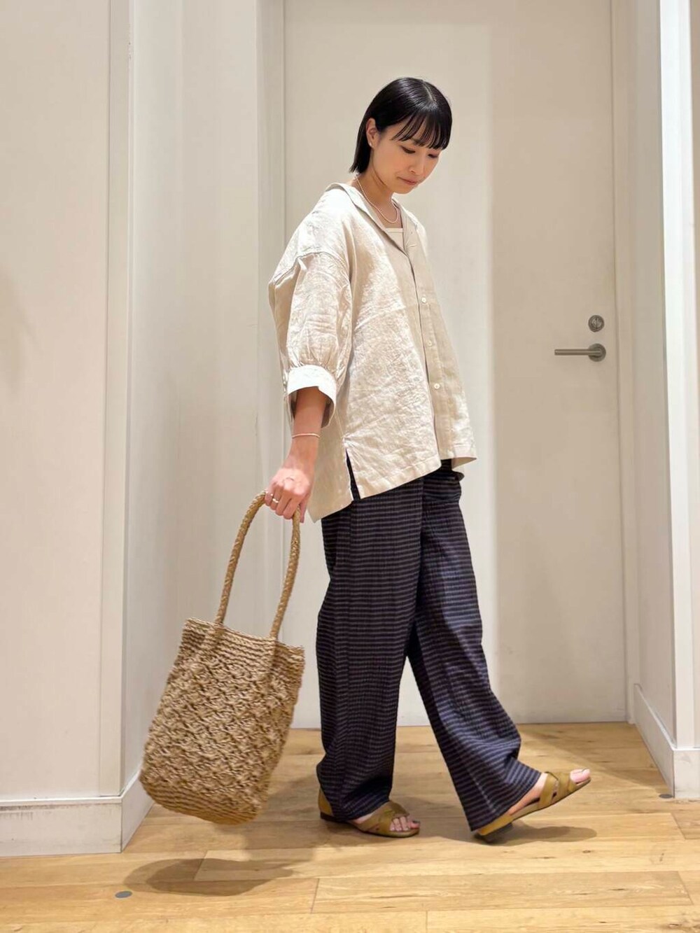 ベージュ系のシャツ/ブラウス、ベージュ系のトートバッグ、イエロー系のサンダルを着用したレディースの夏コーディネートの4枚目の写真