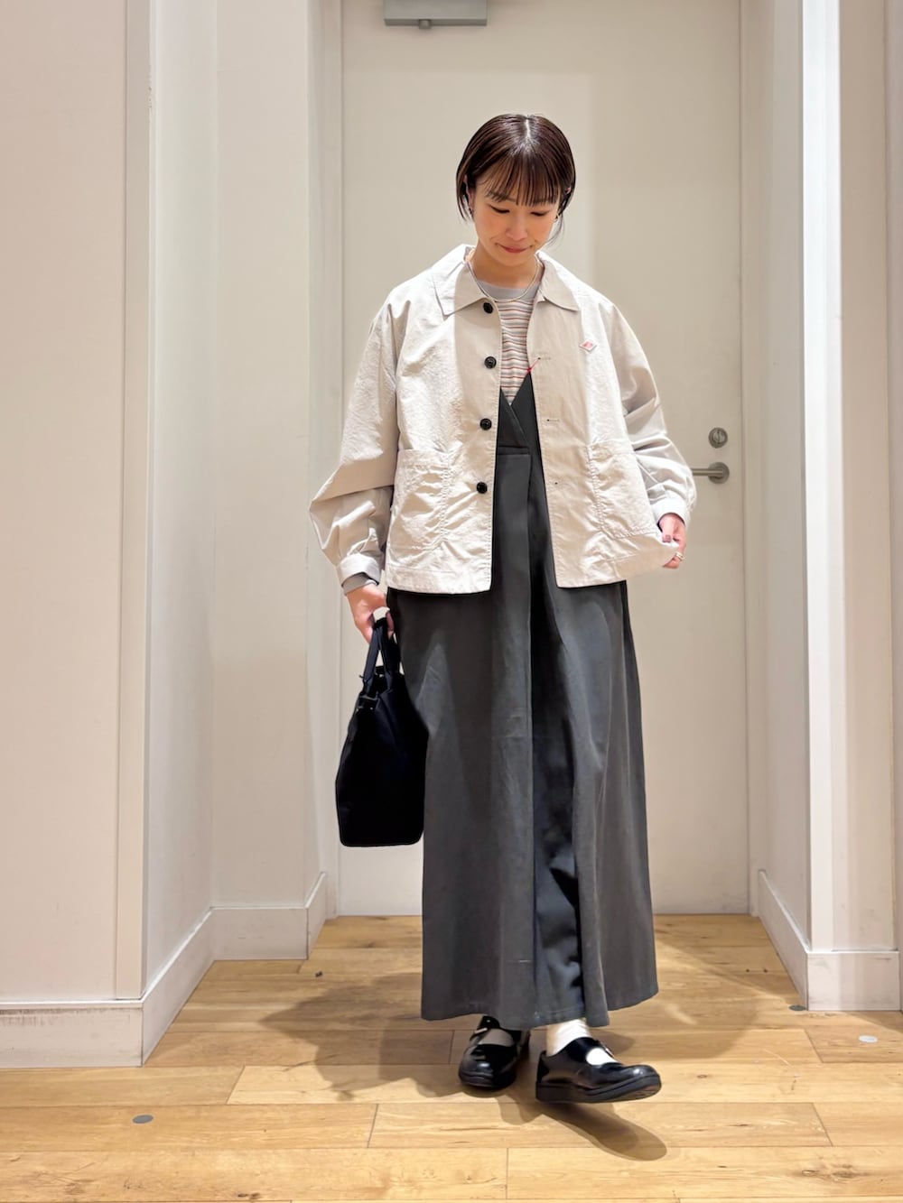 レッド系のスウェット、ベージュ系のテーラードジャケット、グリーン系のワンピースを着用したレディースの春コーディネートの4枚目の写真