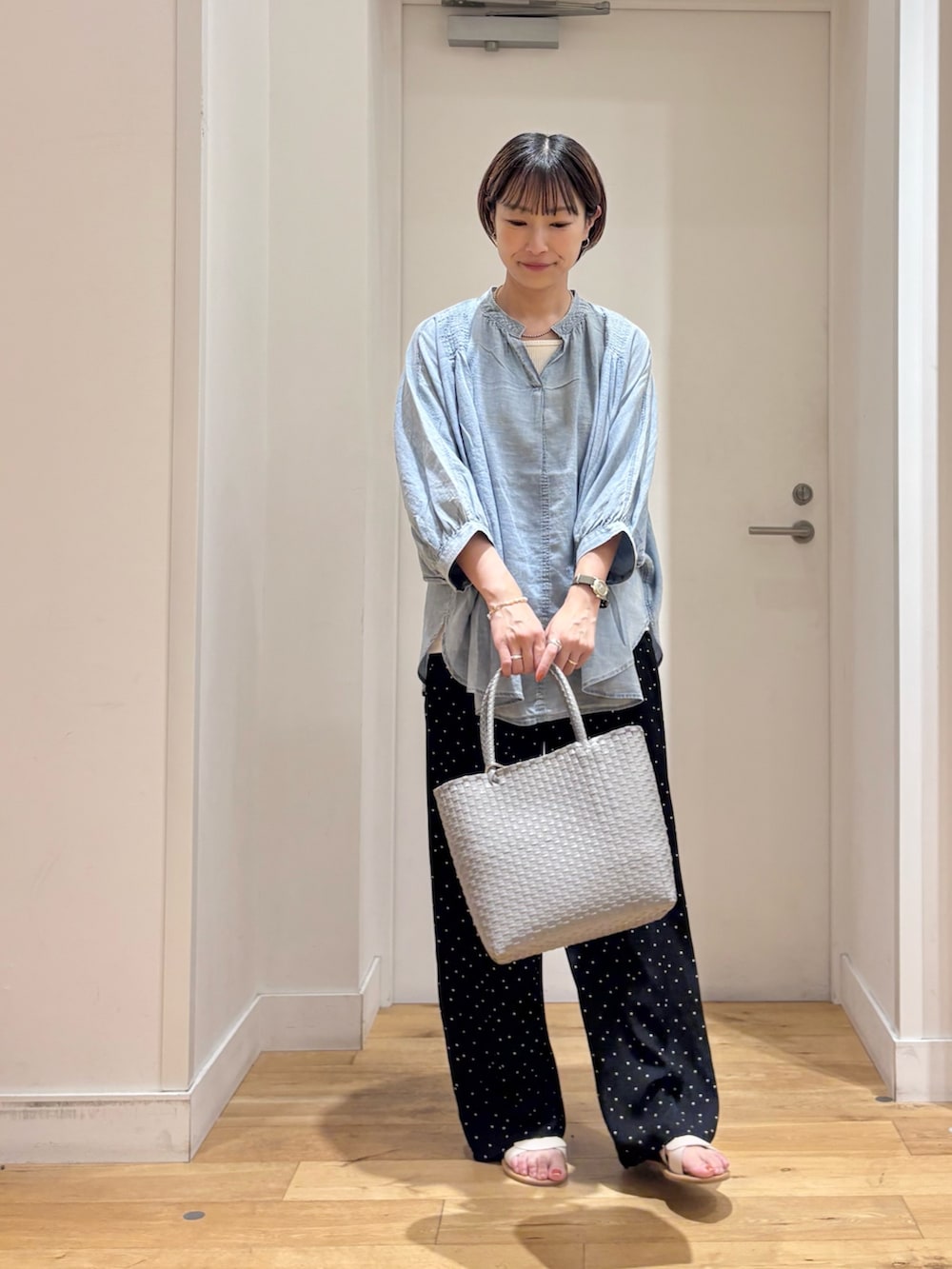 ブラック系のその他パンツ、グレー系のかごバッグ、ホワイト系のサンダルを着用したレディースの夏コーディネートの2枚目の写真