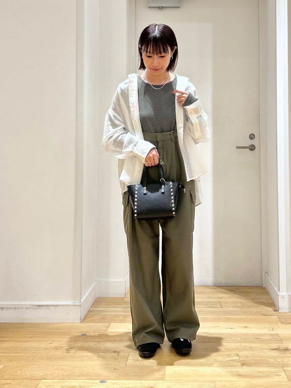 ブラック系のその他シューズ、ブラック系のショルダーバッグ、グリーン系のカーゴパンツを着用したレディースの夏コーディネートの2枚目の写真