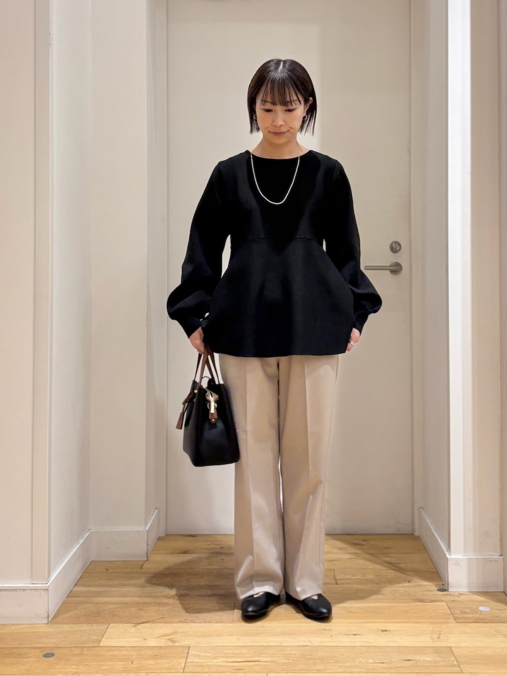 ブラック系のニット/セーター、ベージュ系のその他パンツ、ブラック系のパンプスを着用したレディースの冬コーディネートの4枚目の写真