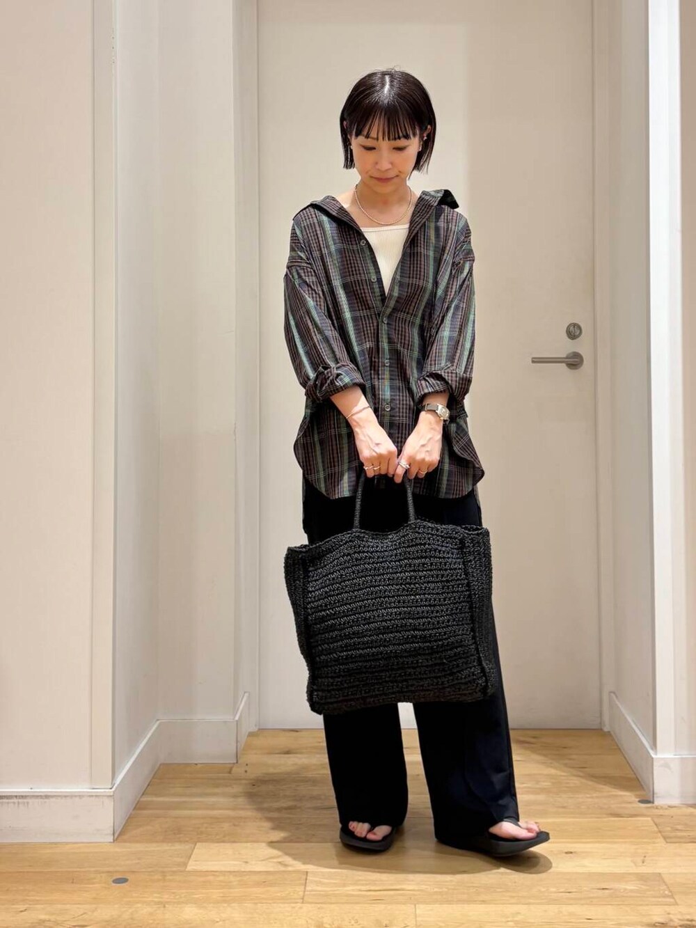 ブラック系のトートバッグ、ブラック系のサンダル、ブラウン系のシャツ/ブラウスを着用したレディースの夏コーディネートの2枚目の写真