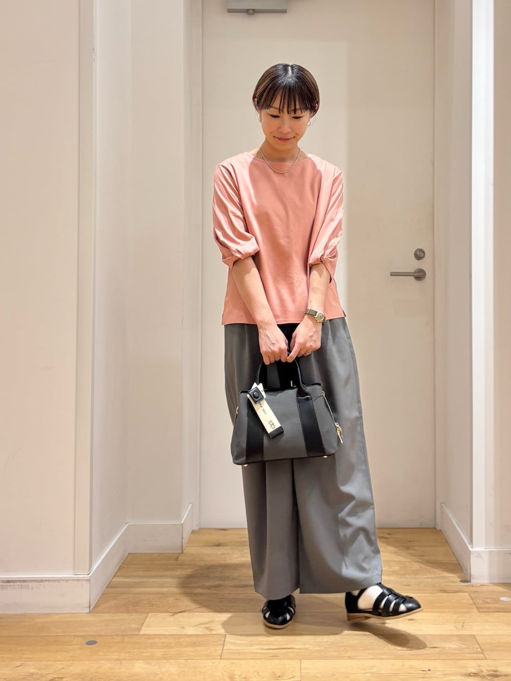 ピンク系のTシャツ/カットソー、グレー系のその他パンツ、ブラック系のサンダルを着用したレディースの春コーディネートの3枚目の写真