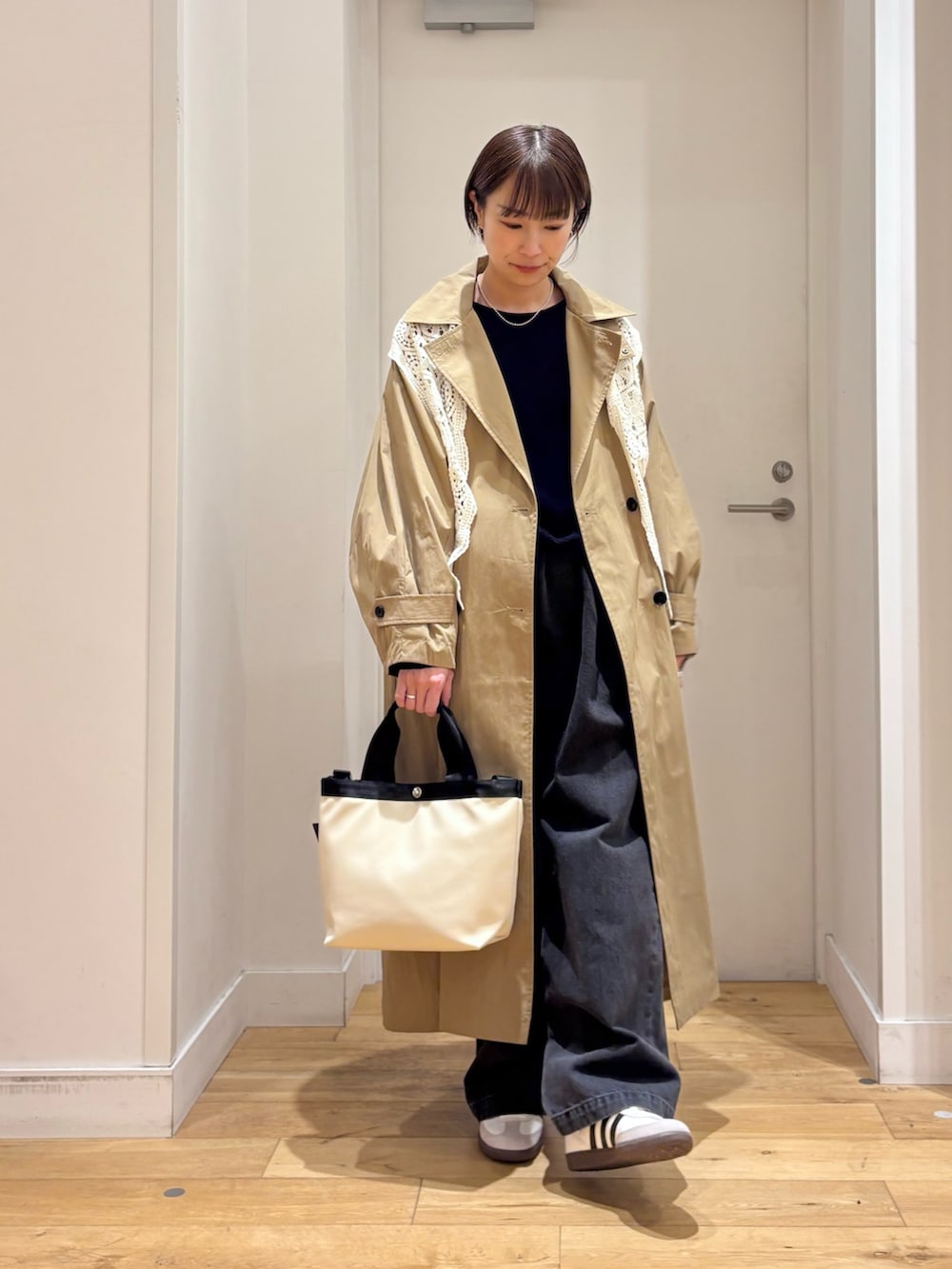 ブルー系のニット/セーター、ブラック系のデニムパンツ、ホワイト系のハンドバッグを着用したレディースの春コーディネートの3枚目の写真