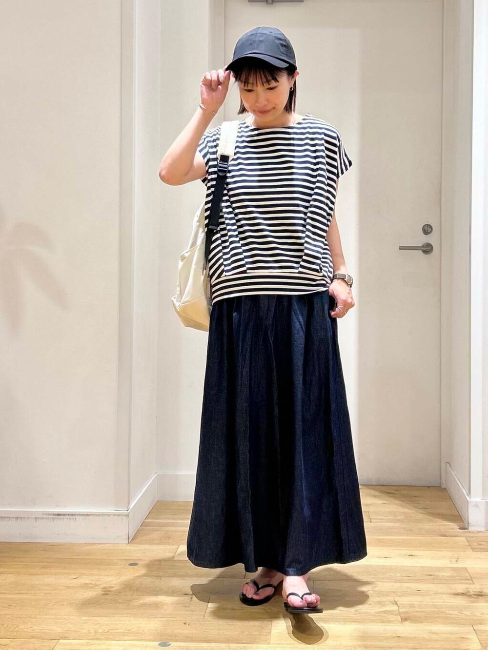 ブラック系のサンダル、ブルー系のTシャツ/カットソー、ブルー系のスカートを着用したレディースの夏コーディネートの2枚目の写真