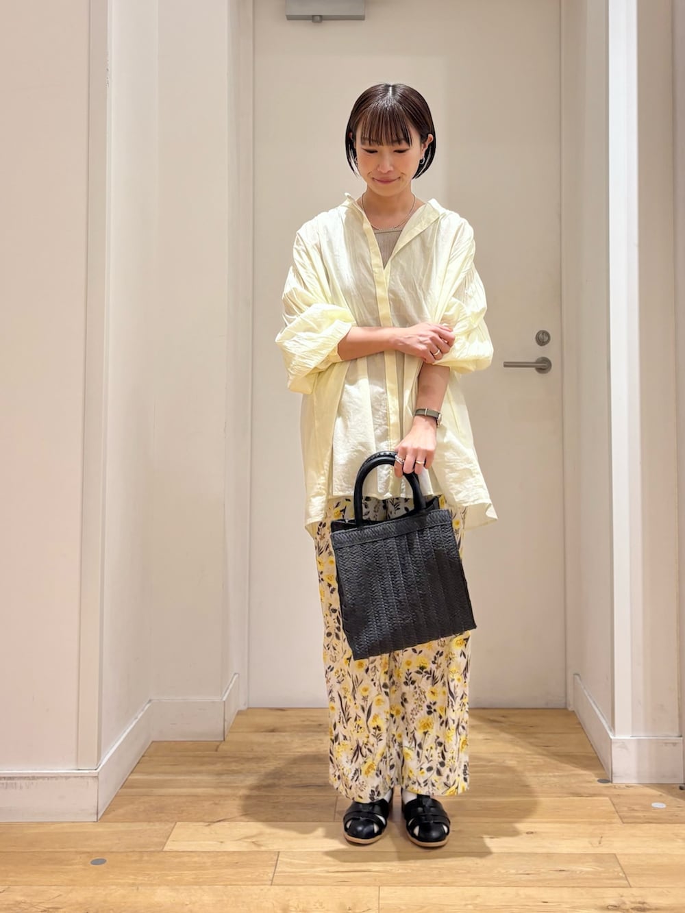 ベージュ系のタンクトップ、イエロー系のシャツ/ブラウス、ブラック系のサンダルを着用したレディースの春コーディネートの3枚目の写真