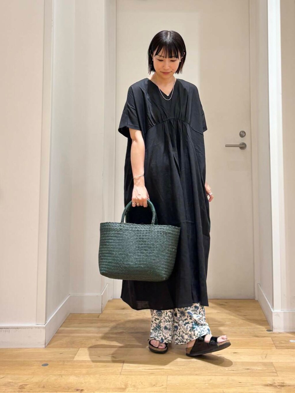 グリーン系のトートバッグ、ブルー系のその他パンツ、ブラック系のワンピースを着用したレディースの夏コーディネートの2枚目の写真