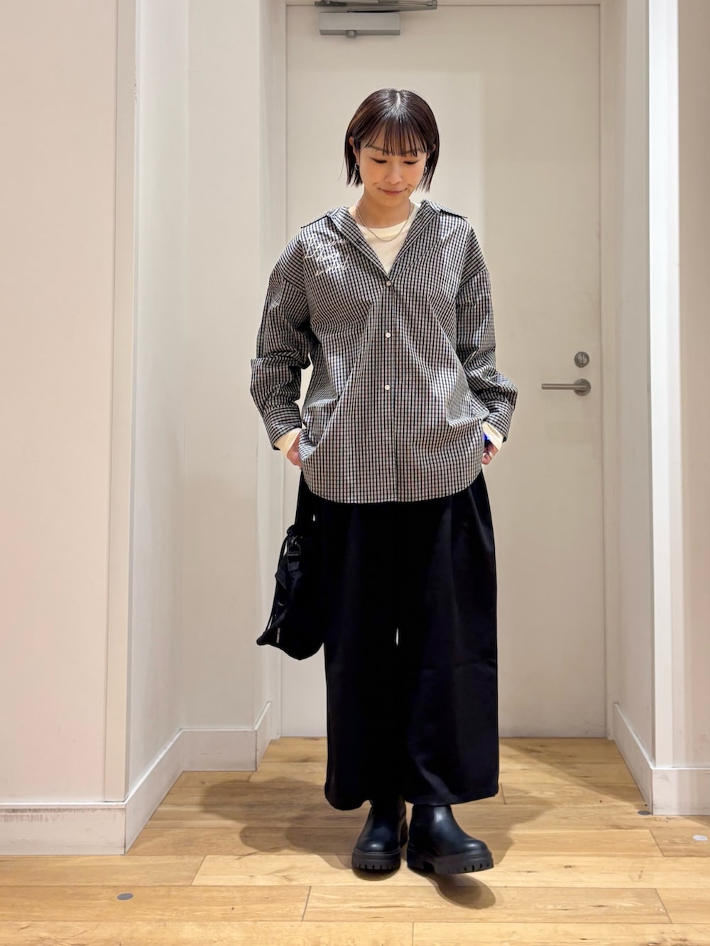 ブラック系のシャツ/ブラウス、ホワイト系のTシャツ/カットソー、ブラック系のショルダーバッグを着用したレディースの冬コーディネートの2枚目の写真