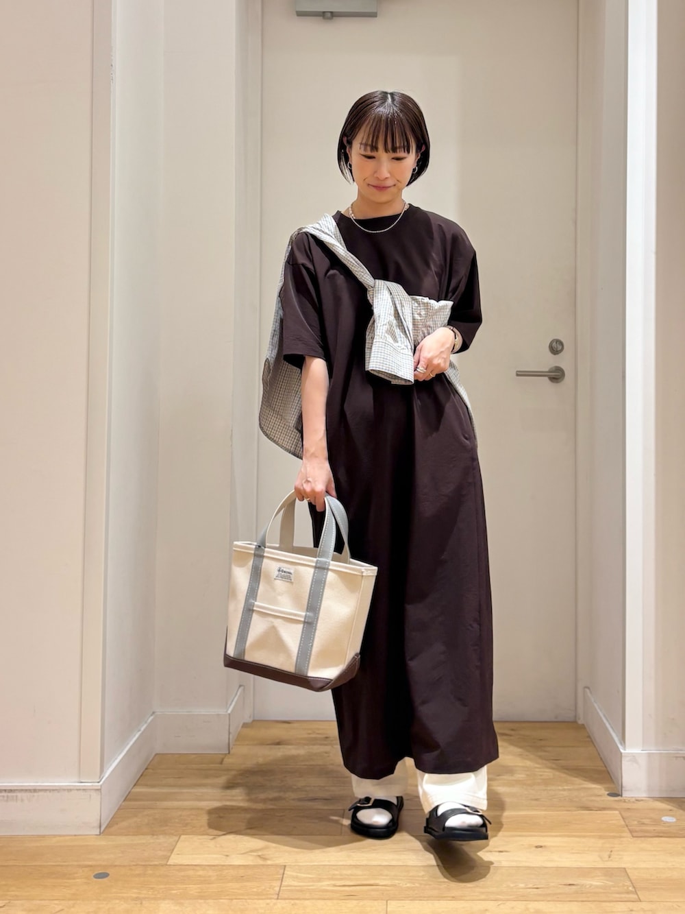 ブラウン系のワンピース、ブルー系のシャツ/ブラウス、グリーン系のトートバッグを着用したレディースの春コーディネートの4枚目の写真