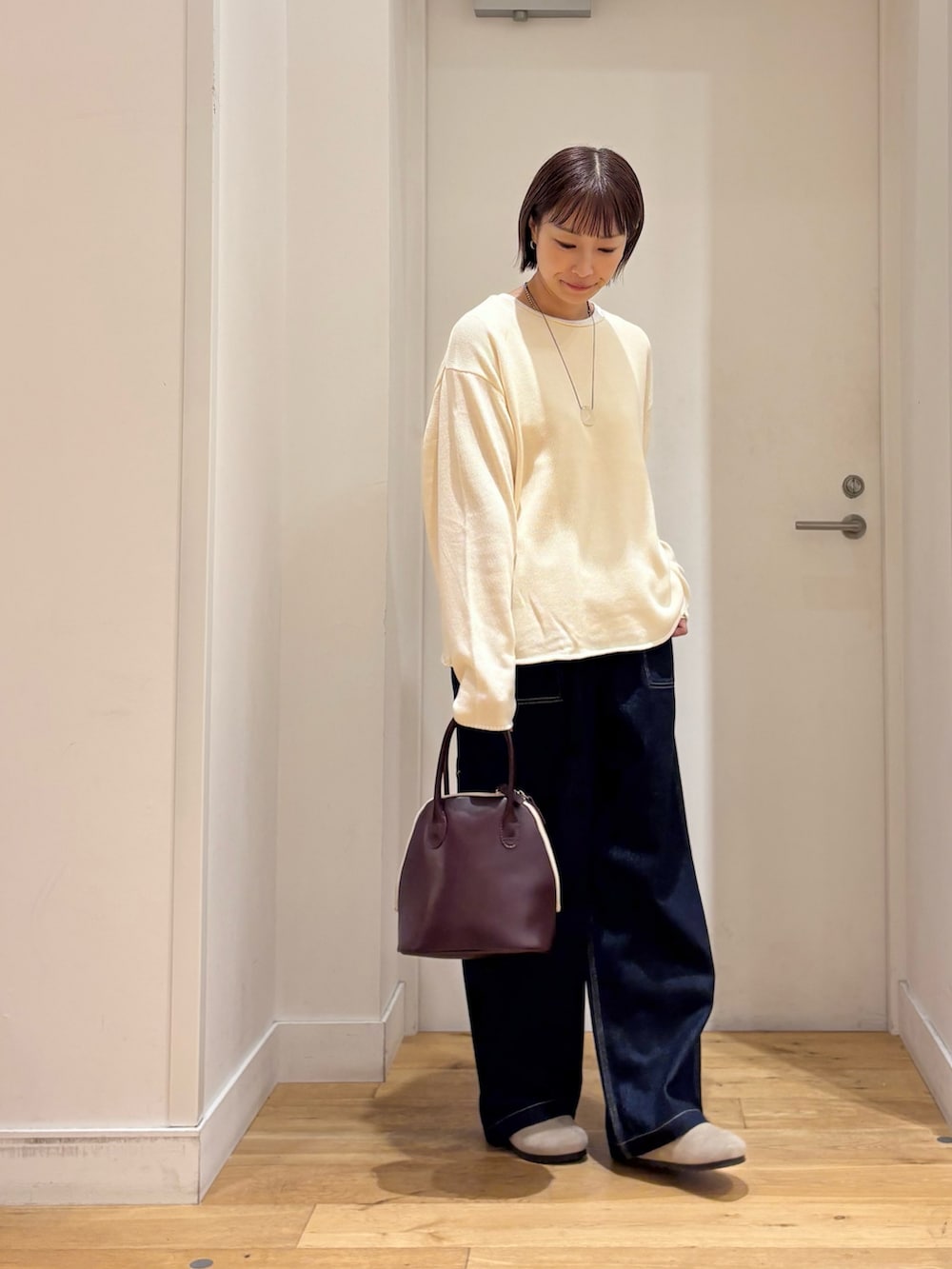 ホワイト系のニット/セーター、ブルー系のデニムパンツ、ベージュ系のその他シューズを着用したレディースの秋コーディネートの5枚目の写真