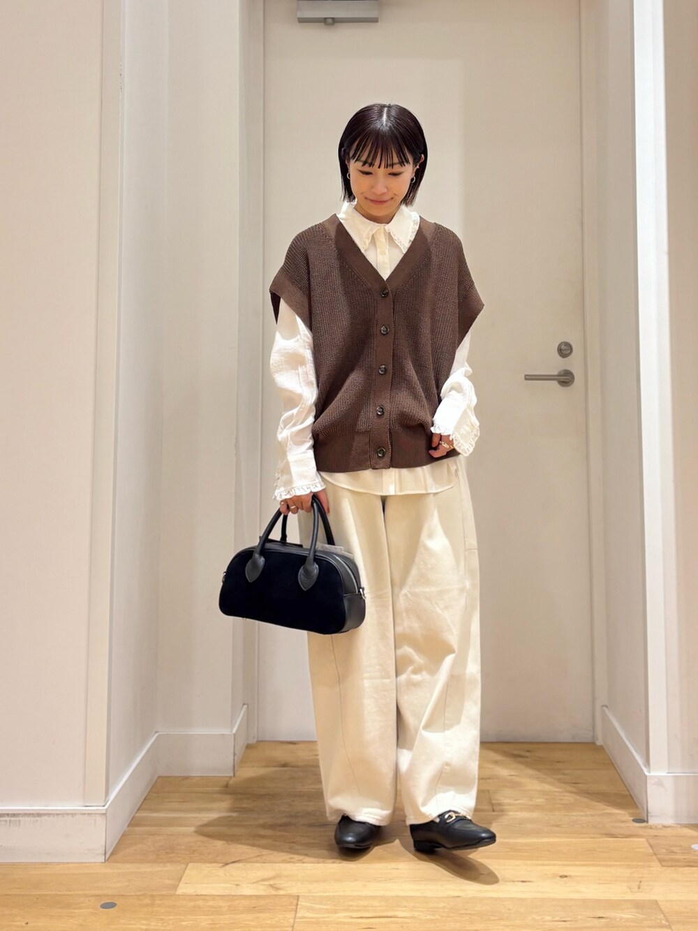 ブラウン系のベスト、ホワイト系のその他パンツ、ホワイト系のシャツ/ブラウスを着用したレディースの秋コーディネートの2枚目の写真