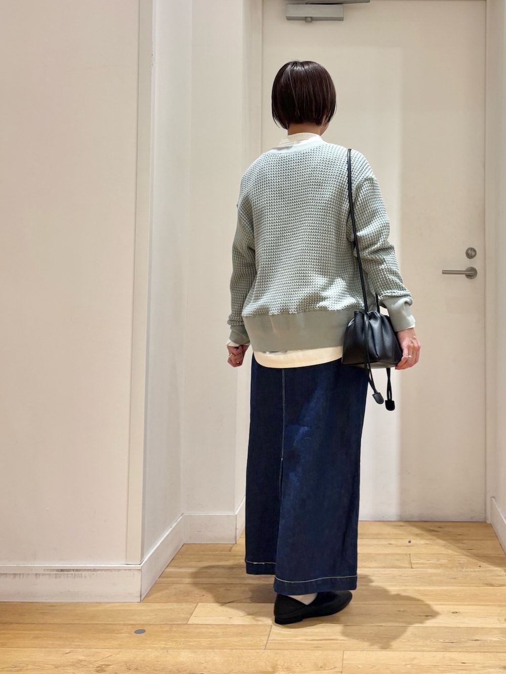 ホワイト系のシャツ/ブラウス、グリーン系のカーディガン/ボレロ、ブルー系のスカートを着用したレディースの春コーディネートの6枚目の写真