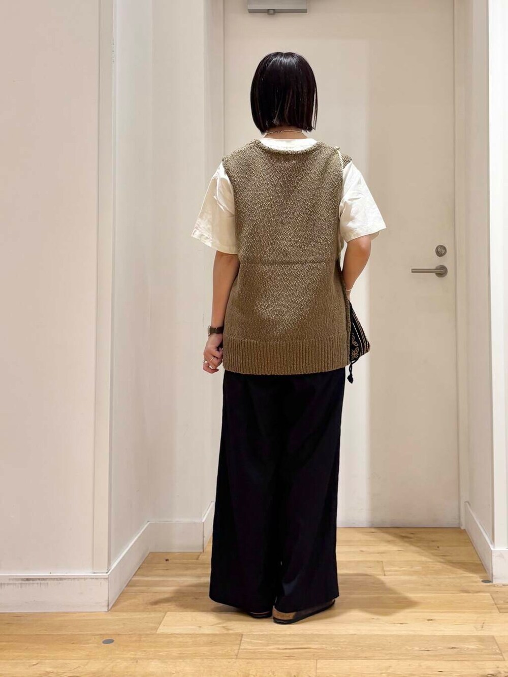 ホワイト系のシャツ/ブラウス、グレー系のサンダル、ブラック系のショルダーバッグを着用したレディースの夏コーディネートの5枚目の写真