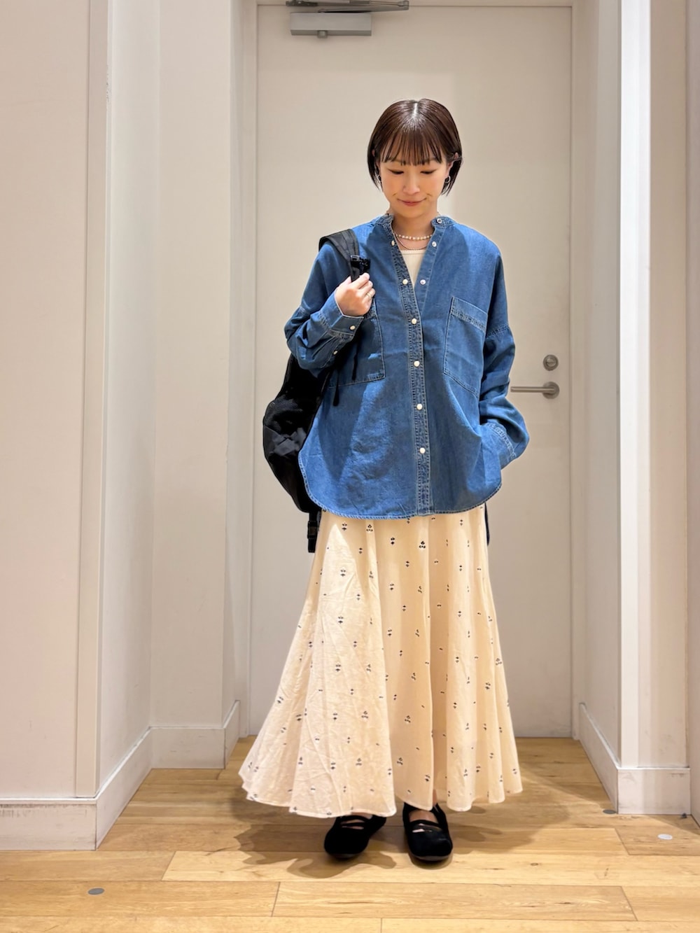 ブルー系のシャツ/ブラウス、ホワイト系のスカート、ブラック系のバックパック/リュックを着用したレディースの春コーディネートの3枚目の写真