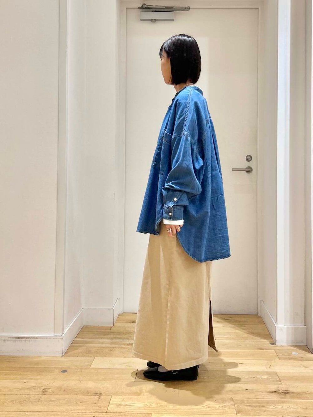 ブラック系のトートバッグ、ブルー系のシャツ/ブラウス、ブラック系のパンプスを着用したレディースの春コーディネートの5枚目の写真